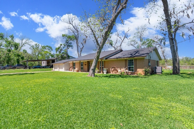 rear view of property featuring a carport, brick siding, a yard, and central air condition unit