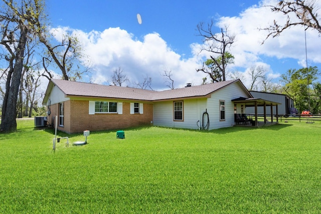 back of house with cooling unit, a lawn, and brick siding