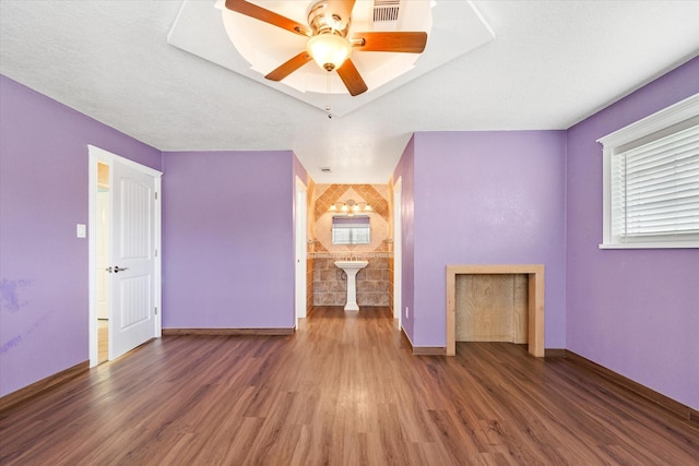 interior space featuring baseboards, a ceiling fan, wood finished floors, and visible vents