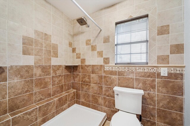 bathroom with a shower stall and toilet
