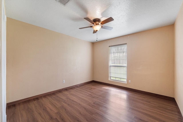unfurnished room with visible vents, baseboards, wood finished floors, and ceiling fan