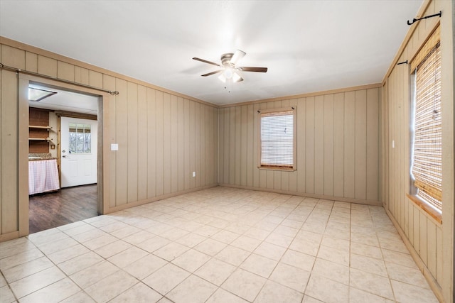 spare room with wooden walls and ceiling fan