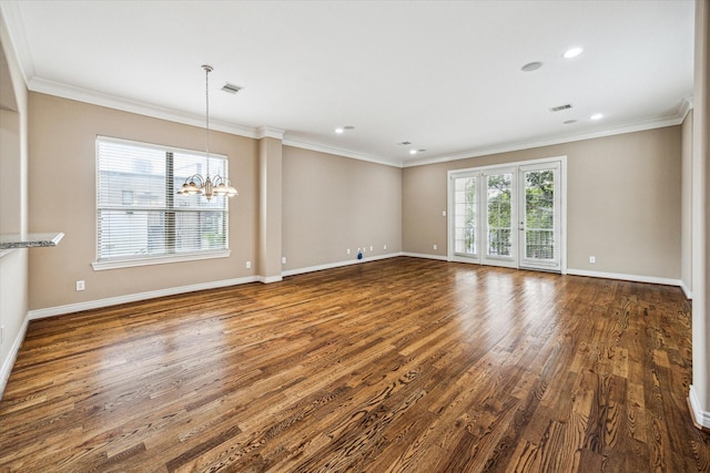 spare room featuring visible vents, baseboards, wood finished floors, and a chandelier