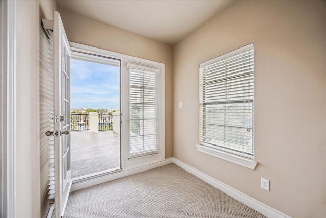doorway with baseboards and carpet flooring
