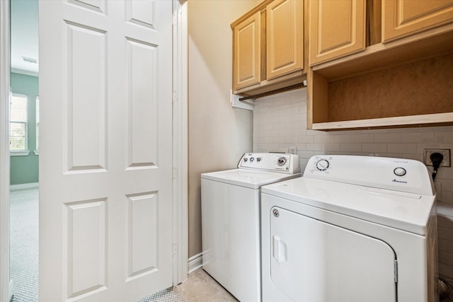 laundry area featuring washing machine and dryer, baseboards, visible vents, cabinet space, and light tile patterned floors