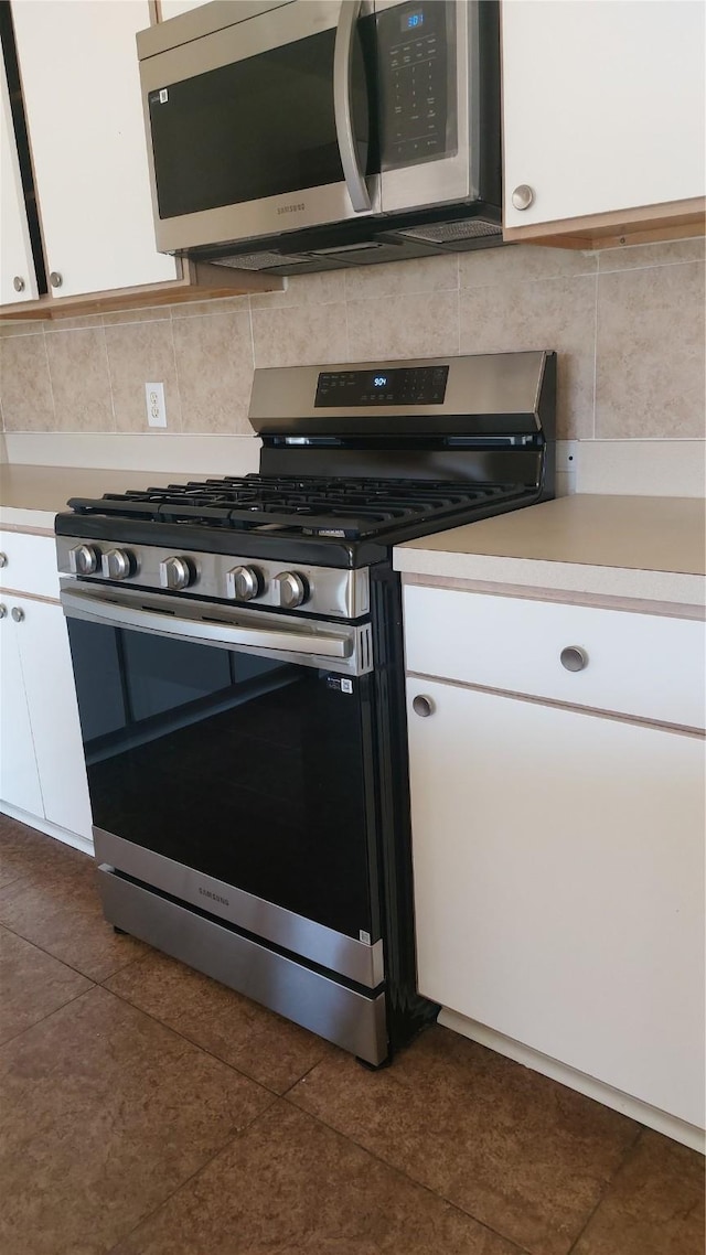 13411 Sarento Vlg, Sugar Land, TX 77498 - kitchen featuring white cabinets, backsplash, stainless steel appliances, and light countertops