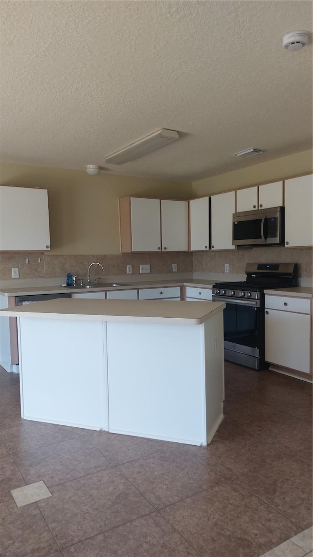 13411 Sarento Vlg, Sugar Land, TX 77498 - kitchen featuring white cabinetry, a textured ceiling, appliances with stainless steel finishes, and light countertops
