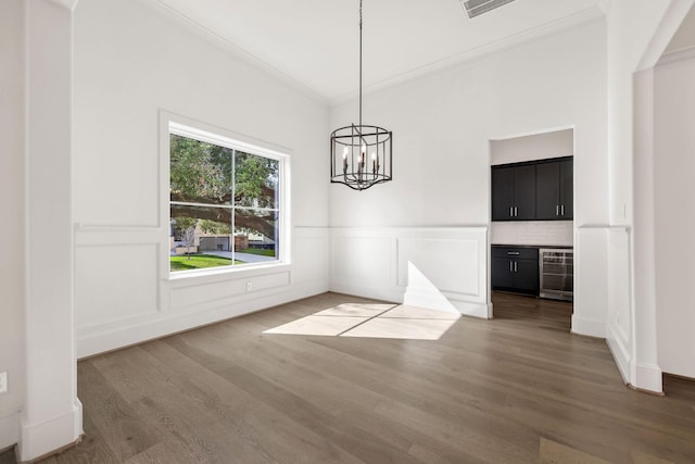 3714 Grennoch Ln, Houston, TX 77025 - unfurnished dining area featuring crown molding, beverage cooler, a bar, wood finished floors, and a wainscoted wall