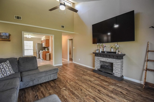 15 Murex St, Bay City, TX 77414 - living room with a ceiling fan, wood finished floors, a towering ceiling, baseboards, and a stone fireplace