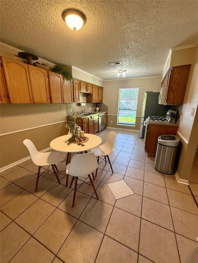 15 Murex St, Bay City, TX 77414 - dining area featuring crown molding, baseboards, a textured ceiling, and light tile patterned flooring