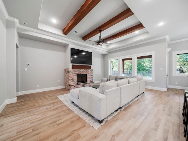 living room featuring light wood-type flooring, baseboards, visible vents, a ceiling fan, and a fireplace