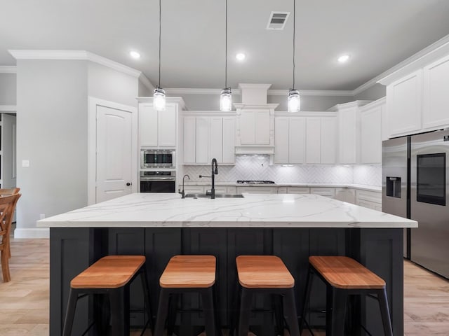 kitchen featuring stainless steel appliances, visible vents, crown molding, decorative backsplash, and white cabinetry