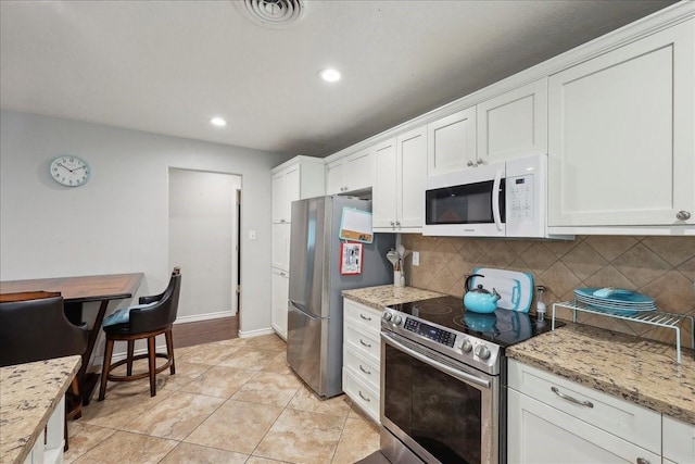 6360 Pansy Dr, Beaumont, TX 77706 - kitchen with stainless steel appliances, visible vents, white cabinetry, and backsplash