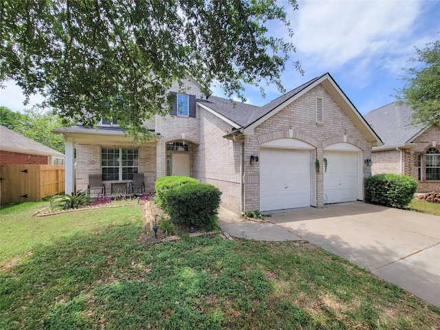 view of front of house featuring fence, a front lawn, driveway, brick siding, and a garage