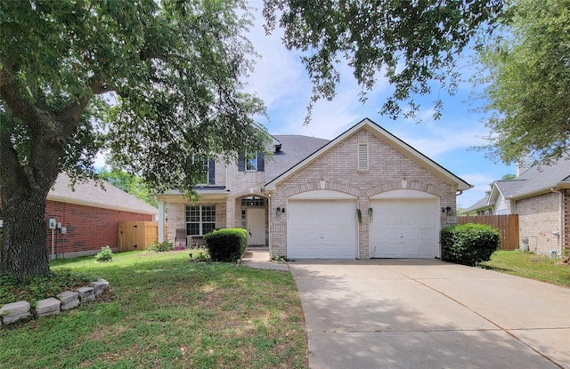 traditional-style home featuring a garage, brick siding, concrete driveway, and fence