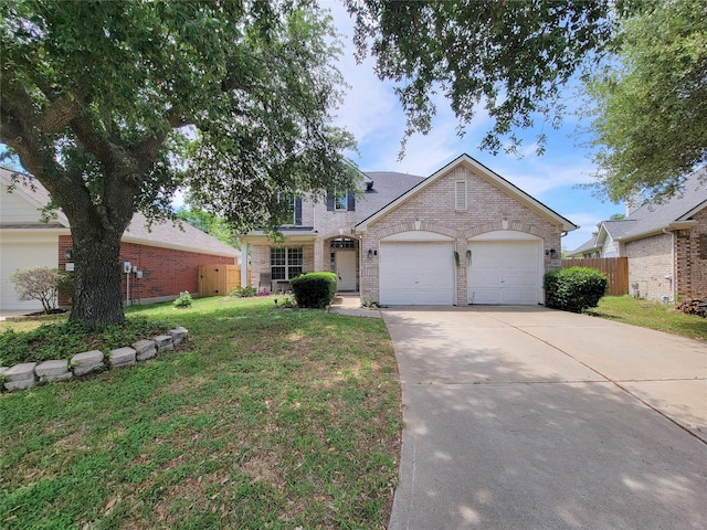 traditional home with concrete driveway, fence, brick siding, an attached garage, and a front yard