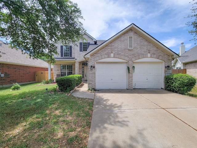 traditional home featuring concrete driveway, fence, brick siding, a garage, and a front yard