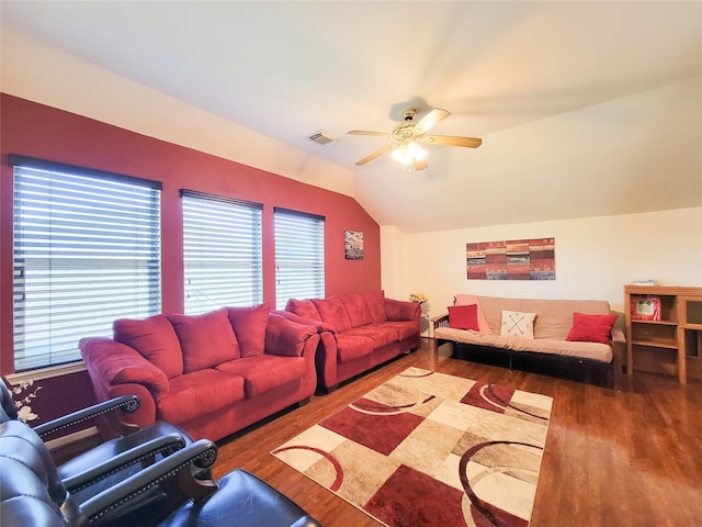 living room with lofted ceiling, visible vents, a ceiling fan, and wood finished floors