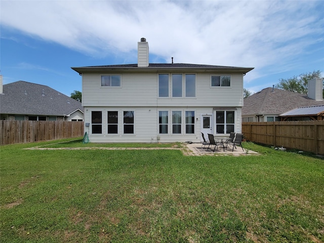rear view of house featuring a lawn, a patio area, and a fenced backyard