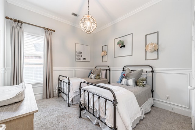 bedroom featuring ornamental molding, carpet floors, a wainscoted wall, a notable chandelier, and visible vents
