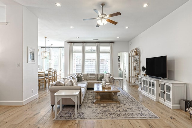 living area featuring ceiling fan, baseboards, light wood-style floors, and recessed lighting