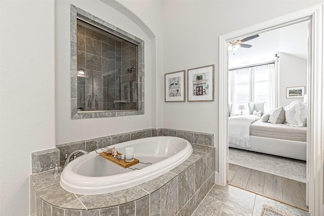 bathroom featuring a tile shower, a bath, ensuite bath, and a ceiling fan