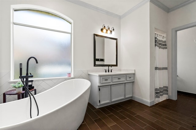 full bathroom featuring crown molding, a freestanding tub, plenty of natural light, and vanity
