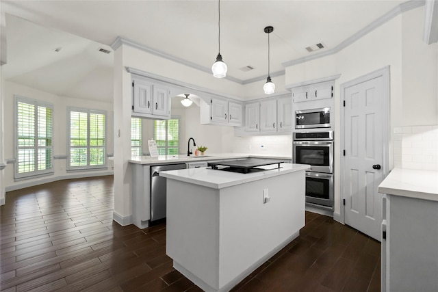 kitchen featuring tasteful backsplash, a kitchen island, dark wood finished floors, and stainless steel appliances