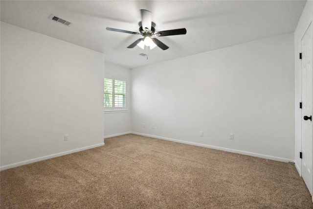 empty room with baseboards, light colored carpet, ceiling fan, and visible vents