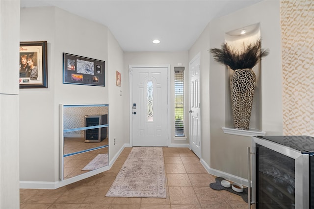 tiled foyer entrance with recessed lighting, a fireplace, beverage cooler, and baseboards