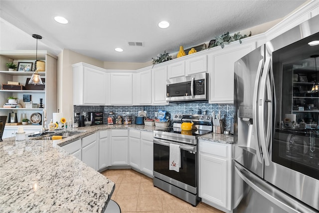 kitchen featuring tasteful backsplash, visible vents, white cabinets, a sink, and stainless steel appliances