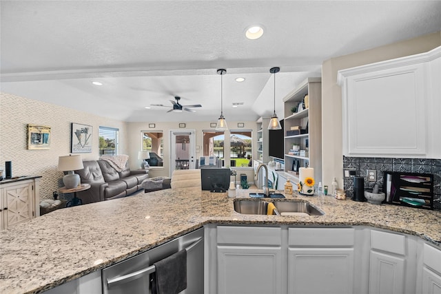 kitchen featuring a sink, a ceiling fan, white cabinetry, and wallpapered walls
