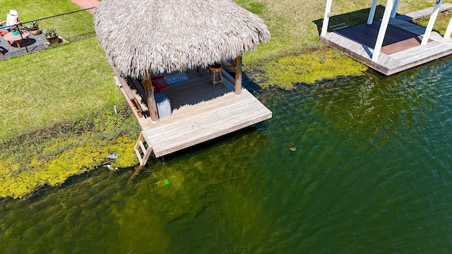 dock area featuring a yard, fence, and a water view