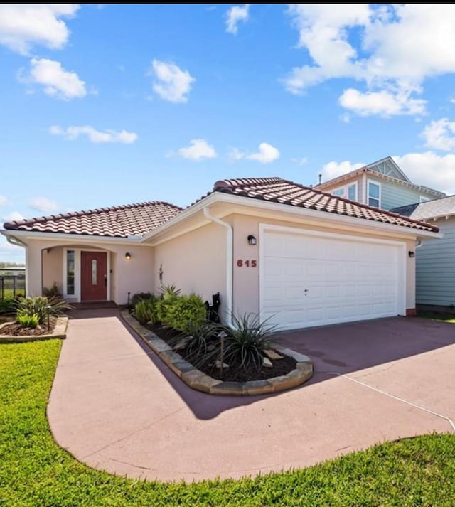 615 28th St, San Leon, TX 77539 - mediterranean / spanish-style house with a tiled roof, driveway, stucco siding, and a garage