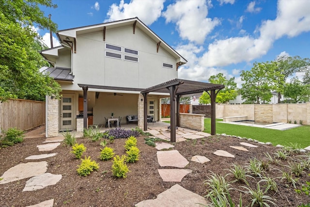 4404 Wendell St, Bellaire, TX 77401 - rear view of property featuring stucco siding, a patio, a fenced backyard, a standing seam roof, and stone siding