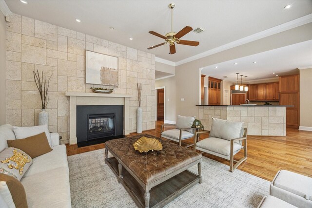 4404 Wendell St, Bellaire, TX 77401 - living room with light wood-style floors, crown molding, a ceiling fan, baseboards, and recessed lighting