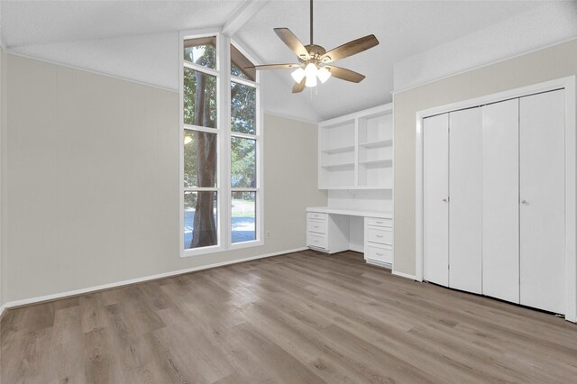3142 La Quinta Dr, Missouri City, TX 77459 - unfurnished bedroom with built in desk, vaulted ceiling with beams, light wood-style floors, baseboards, and ceiling fan