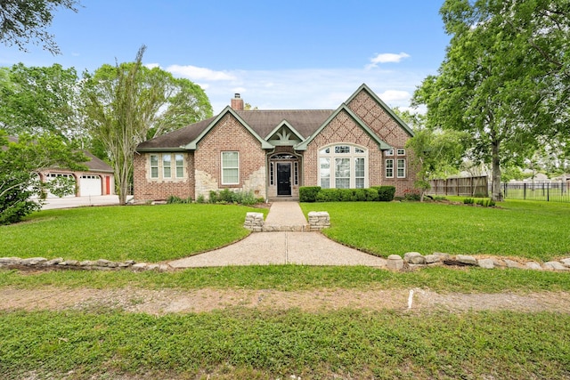 view of front of home featuring brick siding, a chimney, fence, and a front lawn