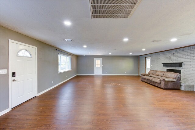 811 Strange Dr, Richmond, TX 77406 - unfurnished living room featuring a fireplace, visible vents, baseboards, and wood finished floors