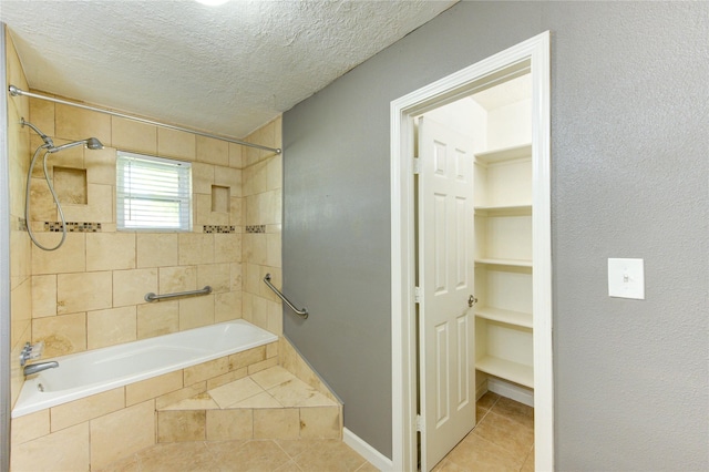 811 Strange Dr, Richmond, TX 77406 - bathroom with tiled shower / bath, tile patterned flooring, baseboards, and a textured ceiling