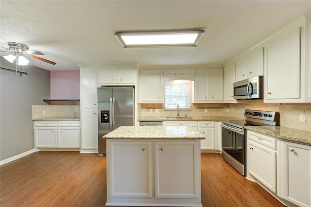 811 Strange Dr, Richmond, TX 77406 - kitchen with a sink, tasteful backsplash, light wood-style flooring, and stainless steel appliances
