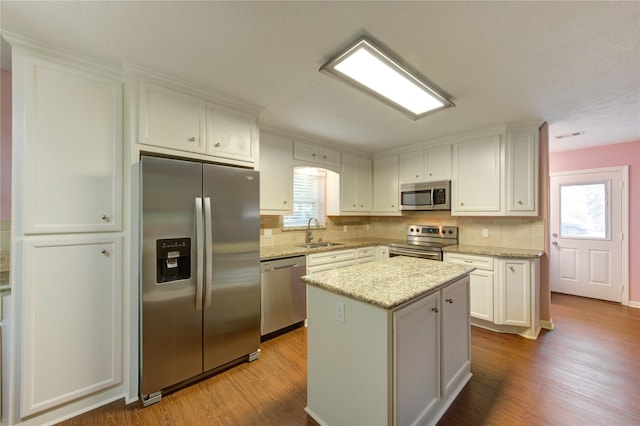 811 Strange Dr, Richmond, TX 77406 - kitchen featuring wood finished floors, tasteful backsplash, a sink, and appliances with stainless steel finishes