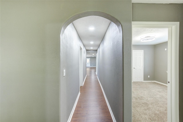 811 Strange Dr, Richmond, TX 77406 - corridor featuring arched walkways, wood finished floors, a textured wall, and baseboards