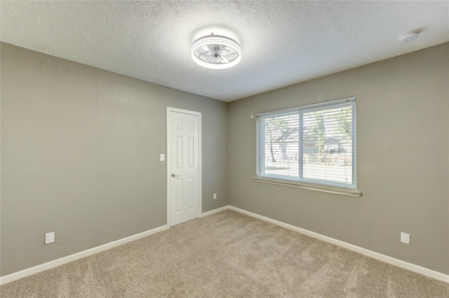 811 Strange Dr, Richmond, TX 77406 - empty room with carpet, a textured ceiling, and baseboards