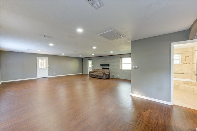 811 Strange Dr, Richmond, TX 77406 - unfurnished living room with a fireplace, visible vents, baseboards, and dark wood finished floors