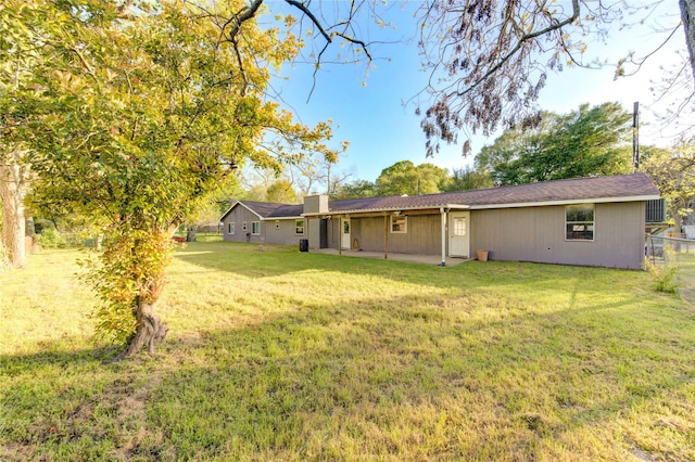 811 Strange Dr, Richmond, TX 77406 - back of property featuring fence, a patio, a lawn, and a chimney