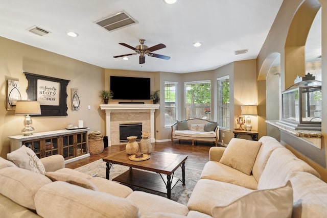 living area with visible vents, baseboards, a ceiling fan, and wood finished floors