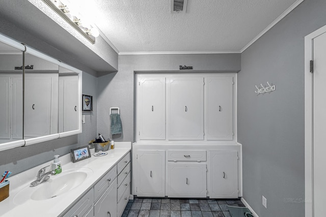 bathroom with a textured ceiling, vanity, crown molding, and visible vents