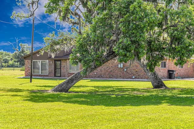 view of front of home featuring brick siding and a front lawn
