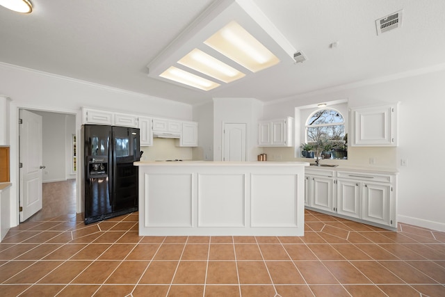 kitchen with crown molding, visible vents, light tile patterned flooring, a sink, and black fridge with ice dispenser